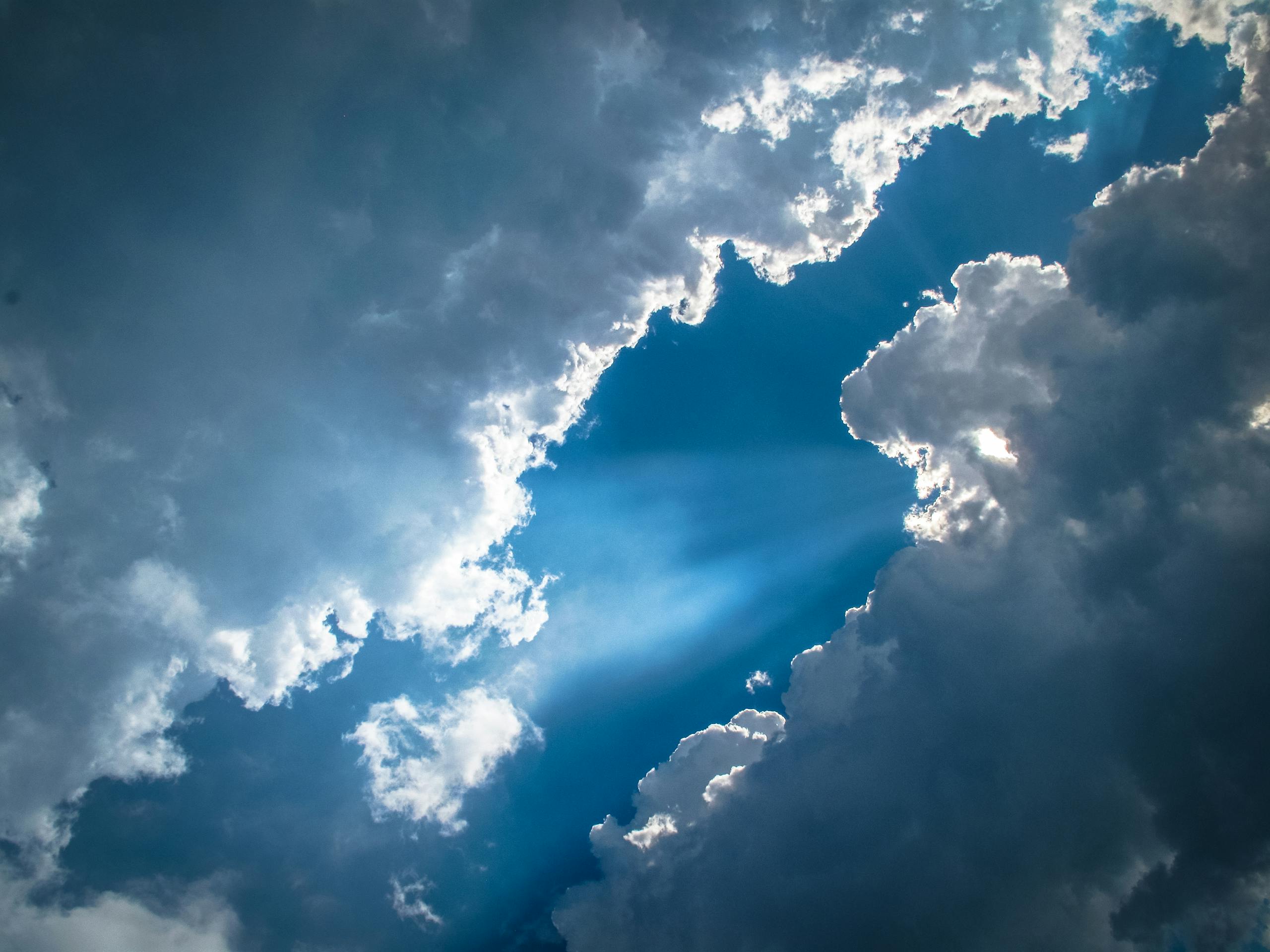 Captivating view of sun rays piercing through dramatic clouds, creating a breathtaking sky scene.